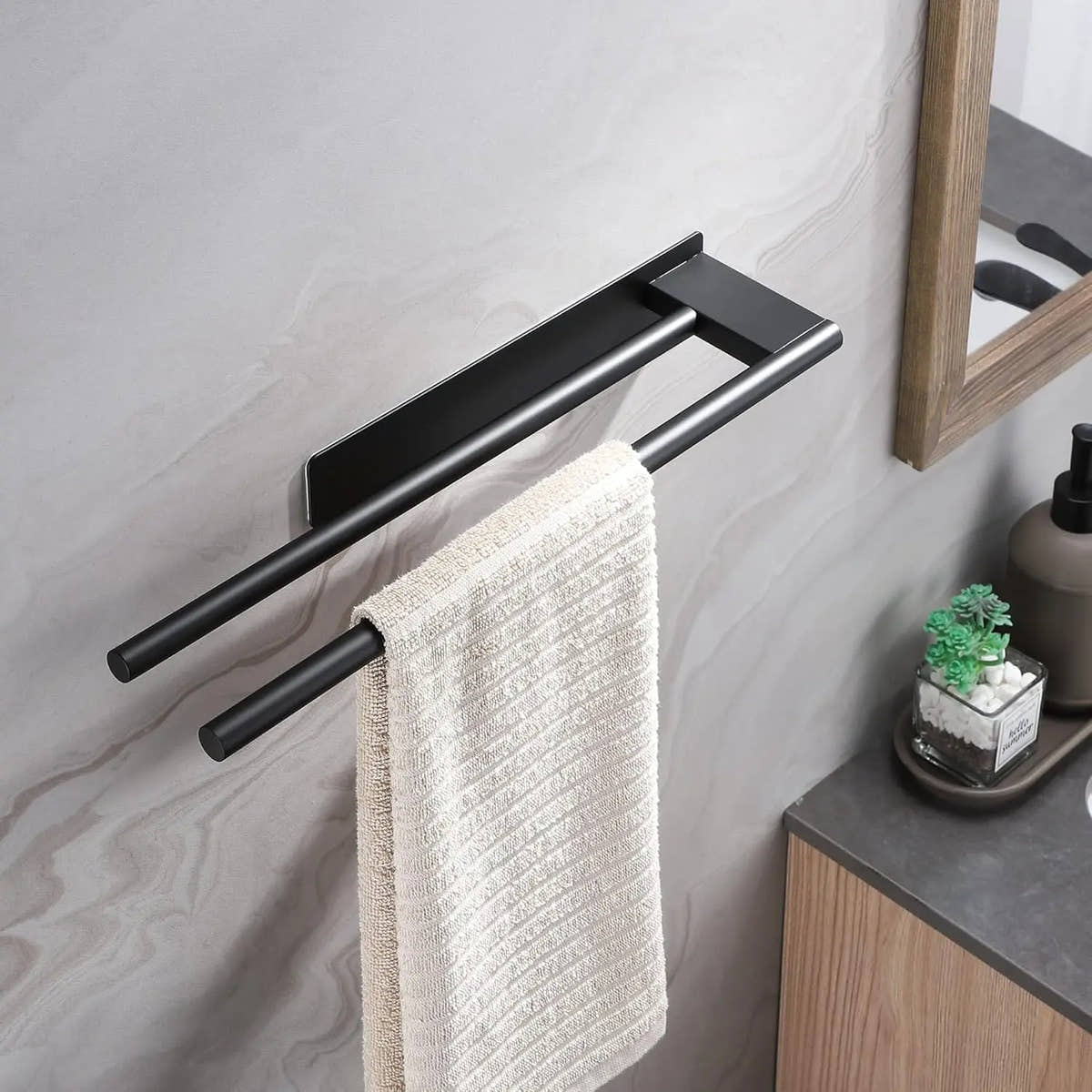 Black adhesive towel bar mounted beside a bathroom sink