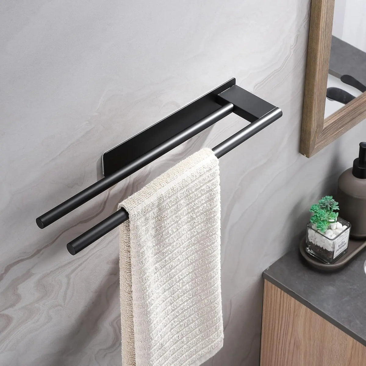 Black adhesive towel bar mounted beside a bathroom sink