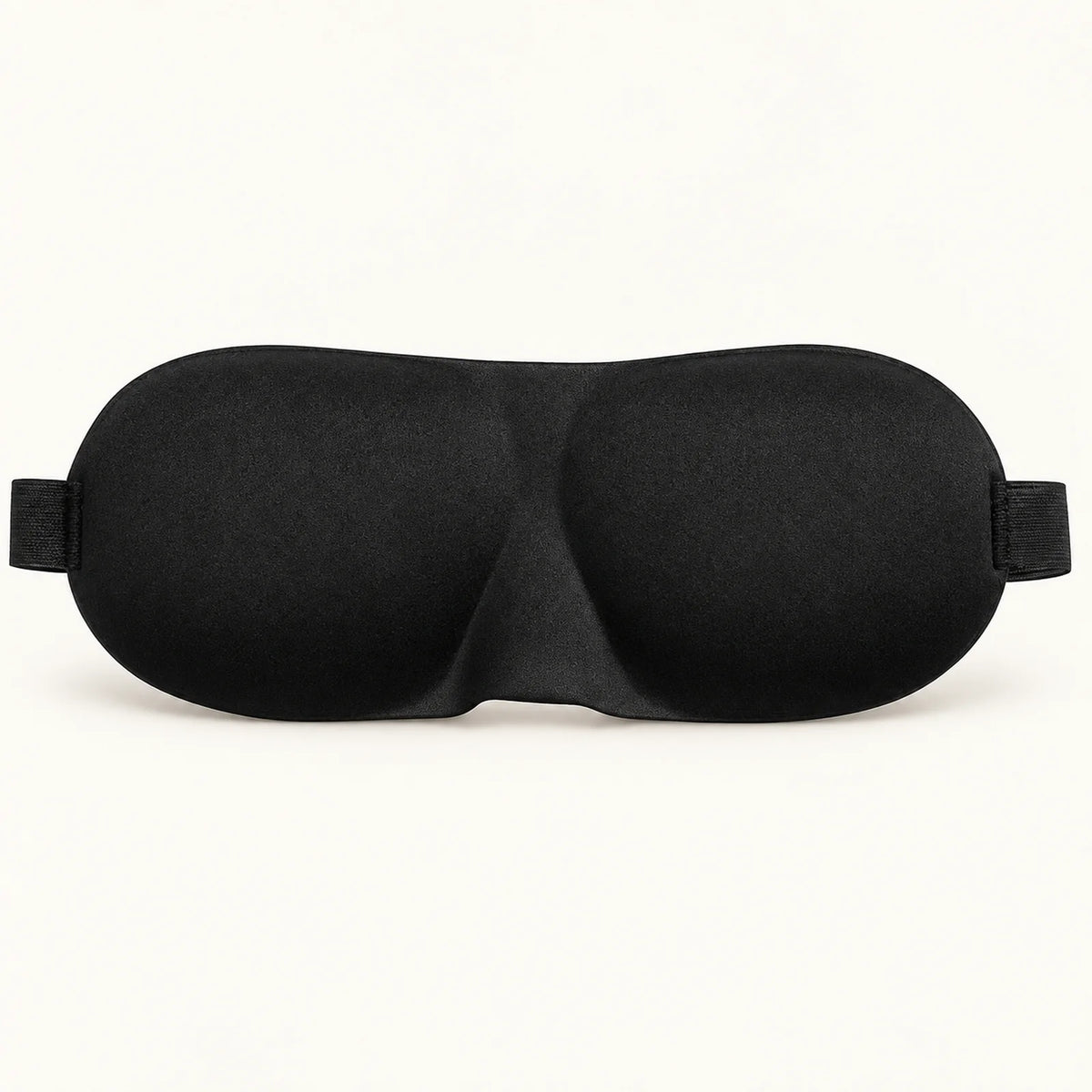Black contoured sleep mask with molded eye cups and elastic strap ends.