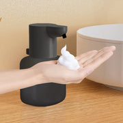 Black touchless dispenser dispensing foam into a hand