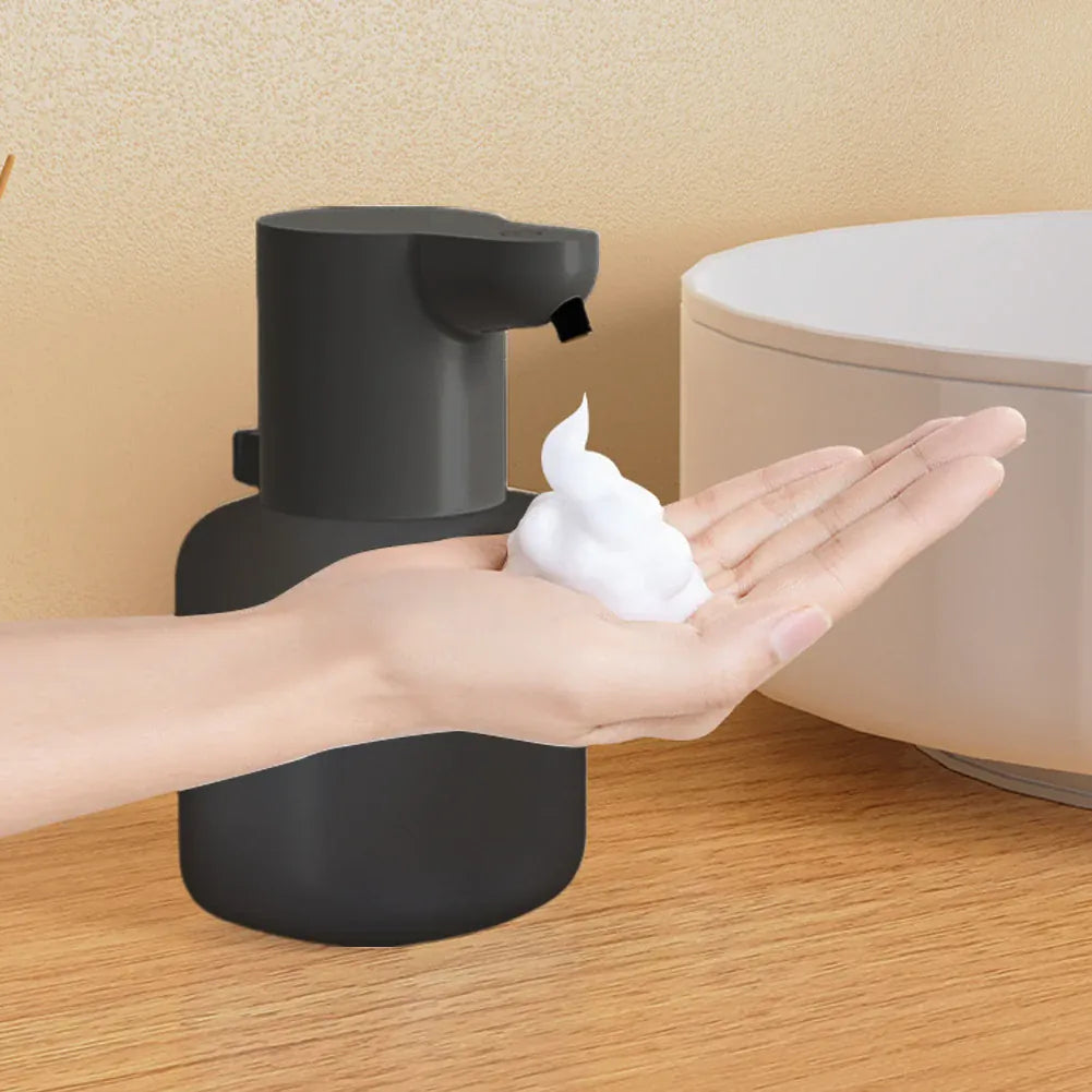 Black touchless dispenser dispensing foam into a hand