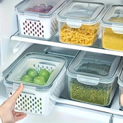 Stackable airtight food storage containers with removable drain baskets organized in a refrigerator