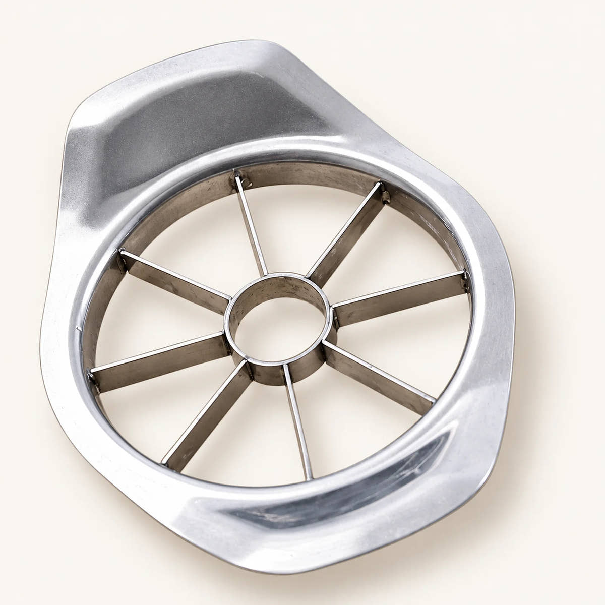 Stainless Steel Apple Cutter on a warm off-white background with a soft natural shadow.