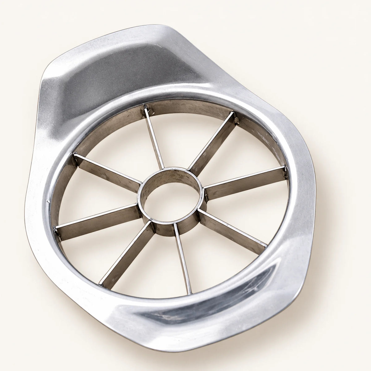 Stainless Steel Apple Cutter on a warm off-white background with a soft natural shadow.