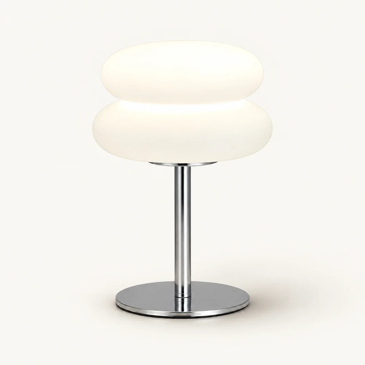 Bedside lamp with two rounded cream shade sections, chrome stem and round chrome base on an off-white background.