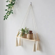 Two-tier macrame wall shelf holding potted plants