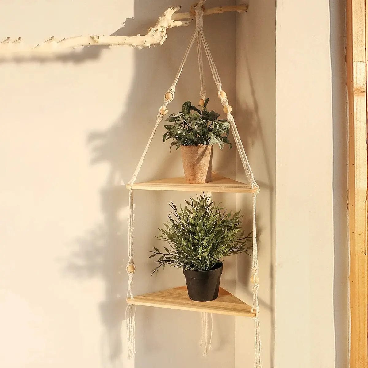 Three-tier macrame corner shelf holding small plants