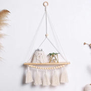 Single-tier macrame wall shelf with fringe and decor