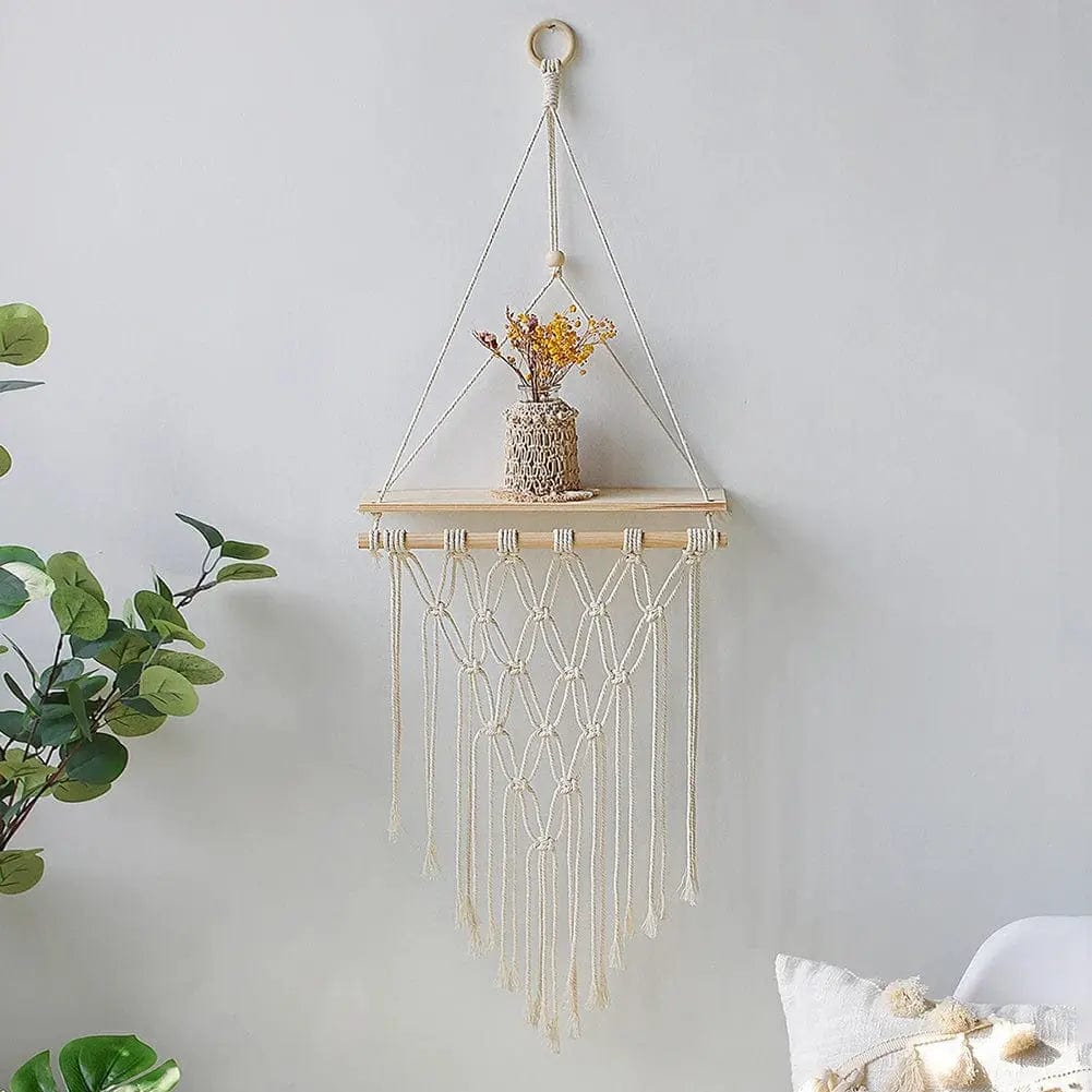 Diamond-shaped macrame wall shelf holding a small plant