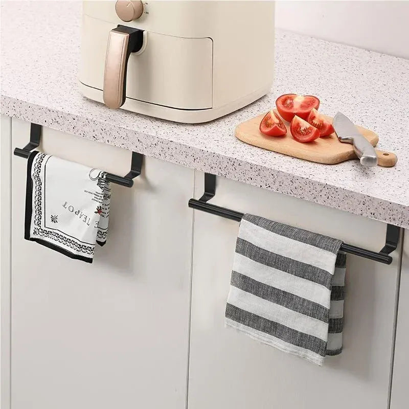 Black over-cabinet towel bars holding kitchen towels