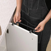 Person hanging the towel bar over a cabinet door