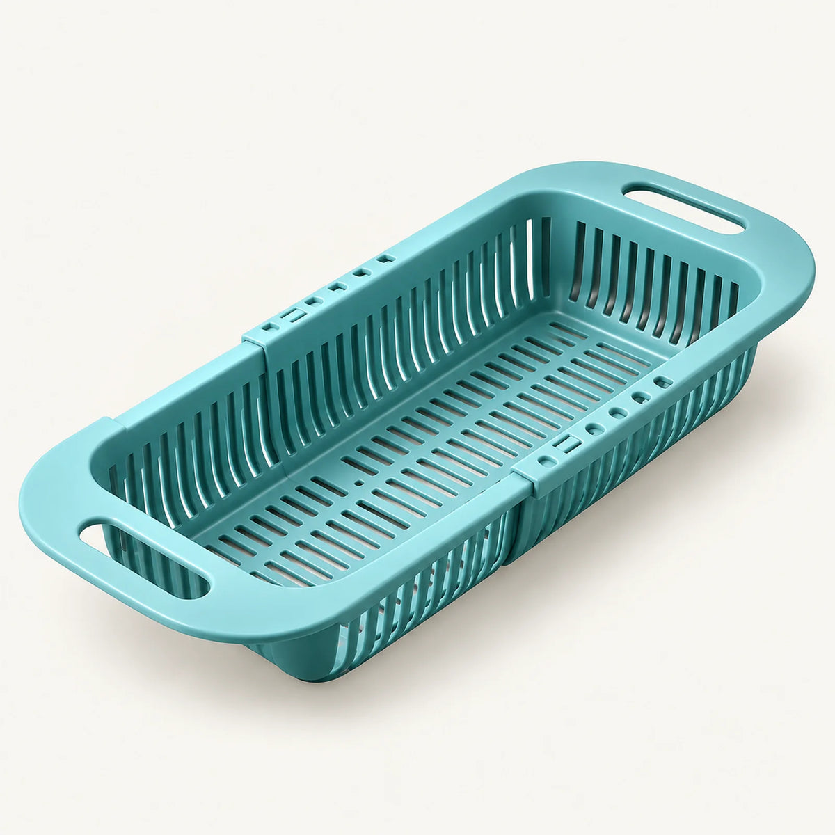 Extendable Over-the-Sink Colander on a warm off-white background with a soft natural shadow.