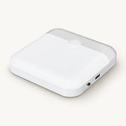 White square motion sensor night light with rounded corners, sensor dome and side controls on an off-white background.
