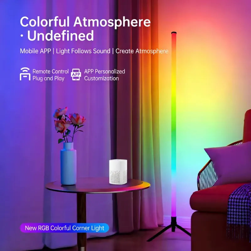 RGB corner floor lamp with a black three-leg base beside a sofa, casting colorful ambient light with app and remote-control icons.