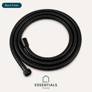 A coiled black flexible corrugated hose with a black connector fitting, shown on a light warm-gray background. A dark teal oval label at the top left reads 'Black Finish,' and the 'ESSENTIALS House' logo appears at the bottom.