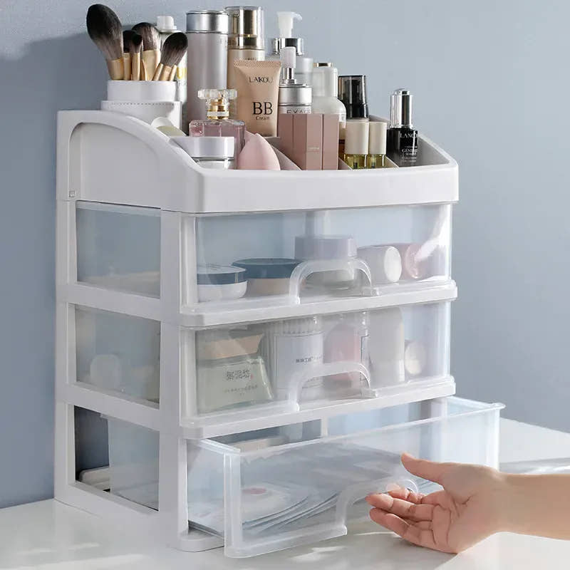 Three-layer clear makeup organizer filled with cosmetics