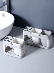 Compact gray toothbrush holder beside a bathroom sink