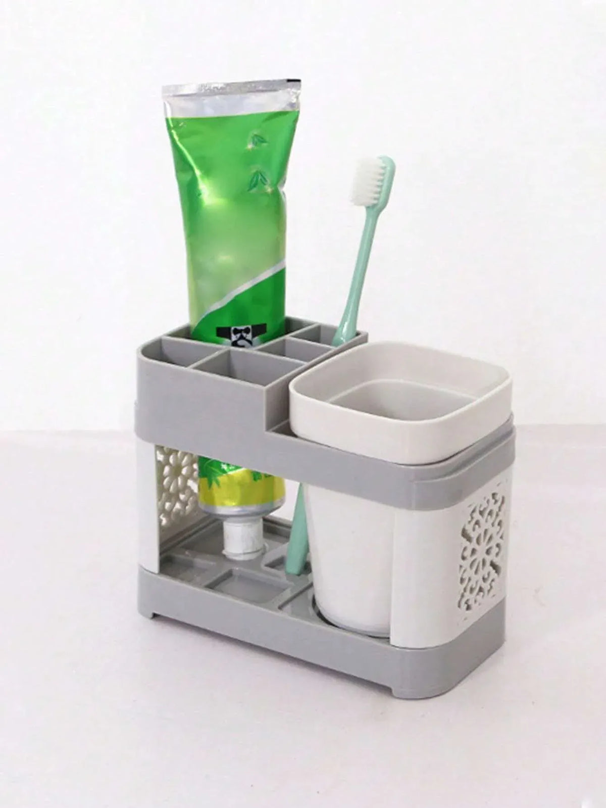 Gray toothbrush holder storing toothpaste and a toothbrush