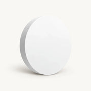 White round Tuya Zigbee scene button shown at an angle on a warm off-white background.