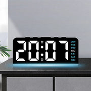 Digital alarm clock with white digits and blue mood light on a cabinet