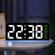 Digital alarm clock with white digits and green weekday labels on a round bedside table