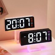 Two digital alarm clocks with orange and purple ambient lighting
