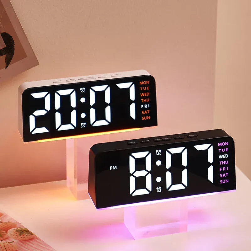 Two digital alarm clocks with orange and purple ambient lighting