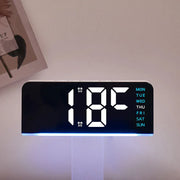 Digital alarm clock displaying temperature with blue ambient light