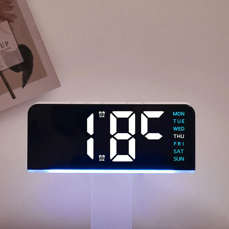 Digital alarm clock displaying temperature with blue ambient light