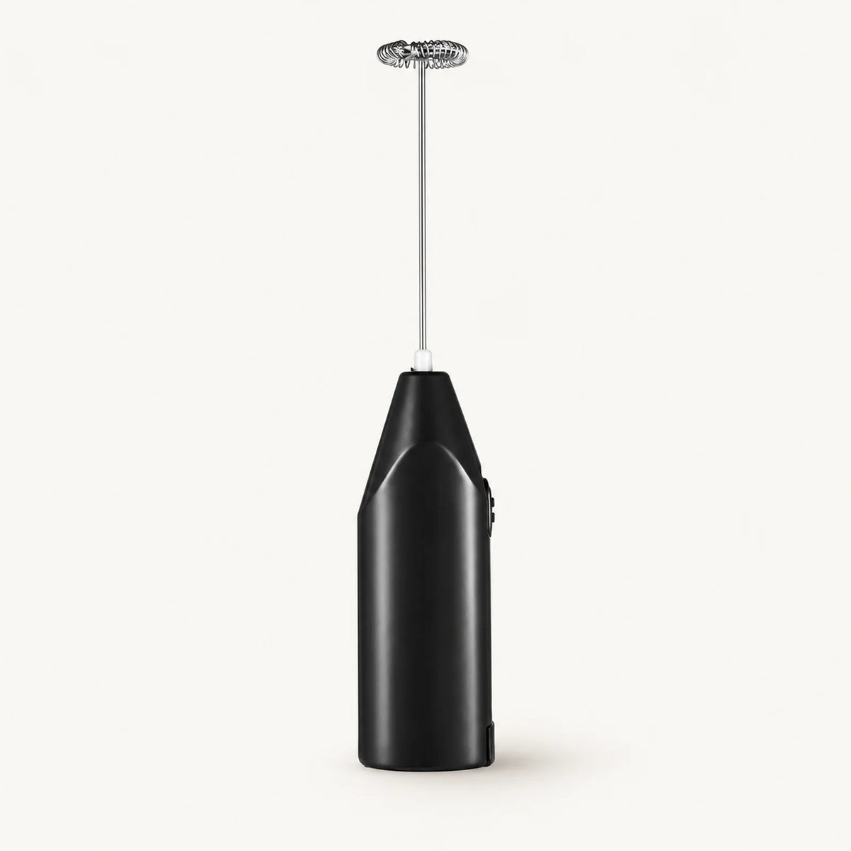 Handheld Milk Frother and Egg Whisk on a warm off-white background with a soft natural shadow.
